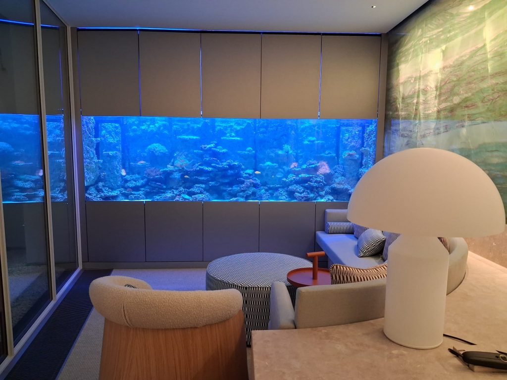 Ein maßgefertigtes Meerwasseraquarium als exklusiver Raumteiler in einem privaten Wellnessbereich in München.